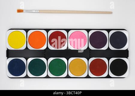 Peinture à l'aquarelle définir les couleurs et le pinceau sur fond blanc. Banque D'Images