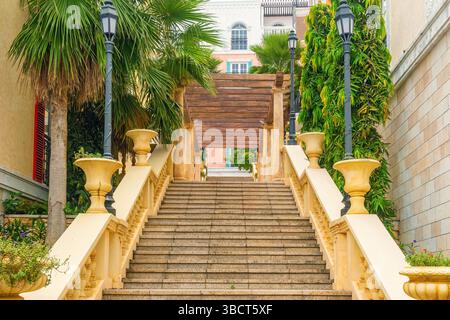 Escalier en pierre élégant avec balustrades et jardinières menant à une pergola en bois dans une rue de style méditerranéen à Sunset Town, île de Phu Quoc, Vietnam Banque D'Images