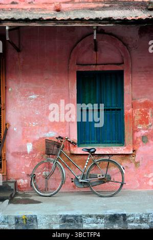 Asie,Inde du Sud ,Etat du Kerala,Kochi (Cochin),bicyclette contre un mur rouge/Old bike dans la ville de Kochi (Cochin),dans l'Etat indien de Keral Banque D'Images