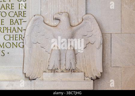 WASHINGTON DC — Une sculpture d'aigle en pierre se trouve bien en vue à l'intérieur du Lincoln Memorial, positionné à côté du mur nord où le deuxième discours inaugural de Lincoln est inscrit dans la pierre. L'aigle, sculpté dans le marbre blanc, est l'un des nombreux éléments décoratifs du monument néoclassique. Le mémorial, inauguré en 1922, rend hommage au 16e président des États-Unis, Abraham Lincoln. L'inscription sur le mur nord présente le deuxième discours inaugural de Lincoln prononcé le 4 mars 1865, tandis que le mur sud affiche l'adresse de Gettysburg. L'intérieur du mémorial est divisé en trois Banque D'Images