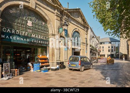 Extérieur du marché historique de Cardiff (Marchnad Caerdydd) par une journée ensoleillée, avec des produits frais exposés à l'extérieur de l'entrée principale sur Trinity Street. Banque D'Images