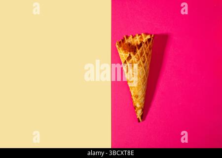 Cône de crème glacée sur fond rose et beige. Concept estival minimal. Pose à plat. Banque D'Images