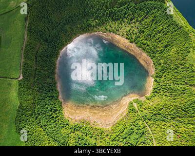 Pittoresque vue aérienne de dessus du lac volcanique Lagoa Rasa. Eau turquoise, forêt et paysage verdoyant. Sete Cidades, Sao Miguel, Açores, Portugal Banque D'Images