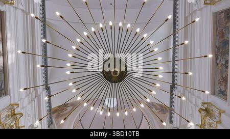 Beau lustre en forme de rayon dans une église catholique. Banque D'Images