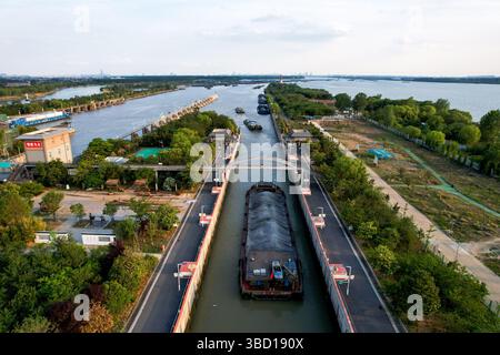 Yangzhou, China.20th mai 2025. Les navires de fret ont poursuivi leur passage régulier à travers la section Yangzhou du Grand canal Pékin-Hangzhou aujourd’hui, maintenant la voie navigable vieille de 2 500 ans comme l’une des routes de navigation intérieure les plus fréquentées au monde, 20 mai 2025. Le canal, site du patrimoine mondial de l'UNESCO depuis 2014, reste vital pour le transport de marchandises nord-sud en Chine. Crédit : Zhang Xiangyi/China News Service/Alamy Live News Banque D'Images