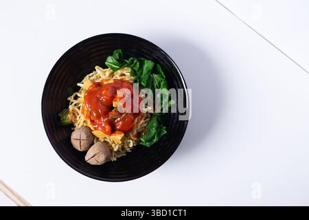 Authentique plat de nouilles asiatiques avec boulettes de viande et légumes frais, prêt à être dégusté. Banque D'Images