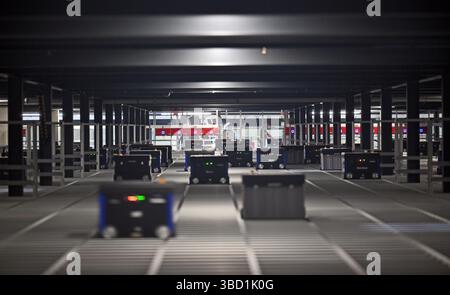 22 mai 2025, Thuringe, Hörselgau : les opérations automatisées d'entrepôt sont présentées lors d'une visite de presse du centre logistique de Rhenus, le nouvel entrepôt central de Thalia en Thuringe. Thalia Bücher GmbH et le groupe Rhenus ont conjointement mis en œuvre un projet qui vise à renforcer le commerce du livre à long terme. Un système automatisé évolutif de stockage et de récupération a été mis en place à cette fin. Environ 240 000 conteneurs standardisés pour le stockage et 530 robots pour la distribution sont disponibles. Photo : Martin Schutt/dpa Banque D'Images