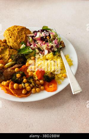Un petit déjeuner sain avec des crêpes lentilles-courgettes, du millet, du cou de poulet rôti, des patates douces, du brocoli, carottes, pois chiches et salade fraîche Banque D'Images