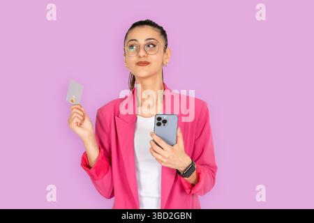 excité positive amusante mignonne femme rêveuse shopping en ligne. Client bancaire utilisant la carte de crédit pour effectuer un paiement facile, tenant le téléphone. internet payant. Banque D'Images