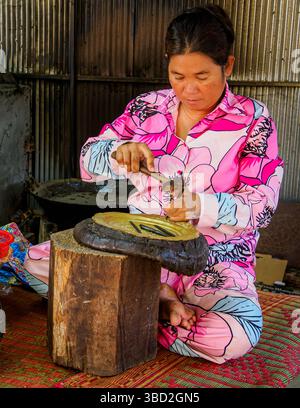 Femme embossant une plaque de bronze au village Silver smith-5, région de Phnom Penh, Cambodge Banque D'Images