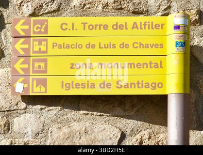Gros plan de quatre panneaux de rue touristiques sur un poteau à côté d'un mur de pierre dans le centre-ville historique de Trujillo Caceres Extremadura Espagne Europe Banque D'Images