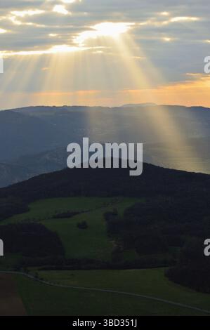 Rayons de lumière divins diffusant à travers le ciel couvert dans un paysage tchèque roulant Banque D'Images