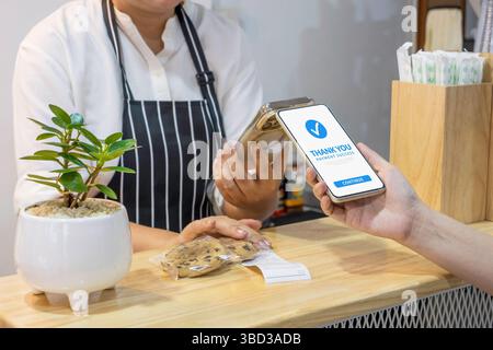 client utilisant un smartphone pour le paiement au café restaurant par portefeuille numérique mobile. Société sans numéraire, numérisation de code QR et transfert d'argent par téléphone Banque D'Images