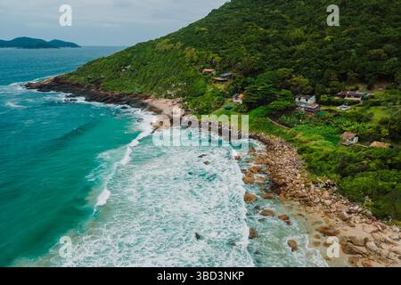 Drone vue sur une plage isolée de l'océan, entourée d'une forêt luxuriante, côte rocheuse au Brésil. Banque D'Images