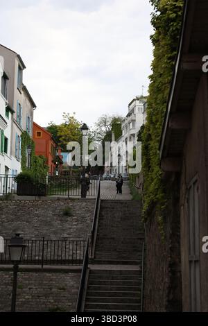 Une charmante rue européenne dispose d'un escalier raide menant à un étroit chemin pavé, encadré par des bâtiments colorés avec volets décoratifs A. Banque D'Images