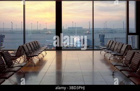 Salon de départ de l'aéroport au coucher du soleil, concept de voyage. Banque D'Images