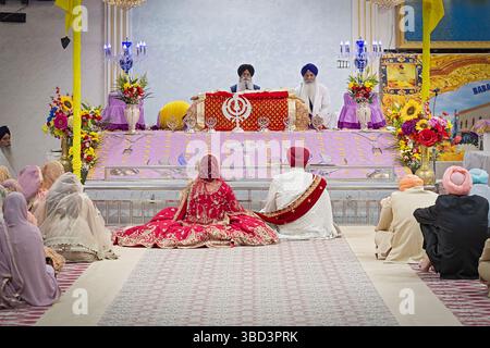 Une photo générique d'un mariage sikh avec une mariée et mariée photographiée de derrière et rendue non identifiable. Dans Un temple à New York. Banque D'Images