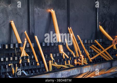 Allumer et allumer des bougies dans le cadre de la prière, de la promesse, de la dévotion et du rituel dans le sanctuaire de Fatima, Portugal. Bougies votives en cire, voeux faits à notre la Banque D'Images