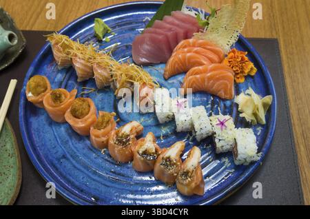 Combiné de différents sushis japonais sur une élégante assiette bleue Banque D'Images