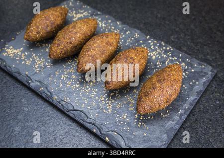 Délicieuse cuisine libanaise (arabe), kibbeh (kibe) sur pierre d'ardoise noire et fond de granit Banque D'Images