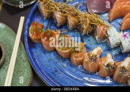 Combiné de différents sushis japonais sur une élégante assiette bleue Banque D'Images