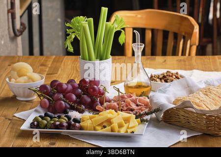Ensemble de divers apéritifs pour le vin, fromage, prosciutto, raisin, olives, noix et céleri Banque D'Images