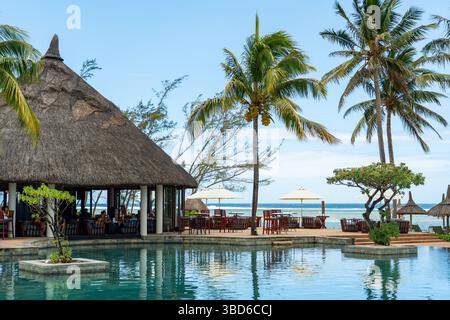 Le Morne, Maurice - 12 mai 2024 : un restaurant en plein air au toit de chaume entouré de palmiers avec vue sur l'océan Indien Banque D'Images