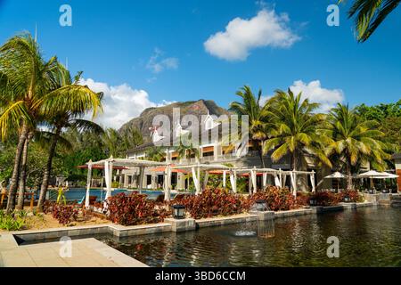 Le Morne, Maurice - 12 mai 2024 : un hôtel tropical avec fontaines et palmiers se trouve sous une montagne spectaculaire Banque D'Images