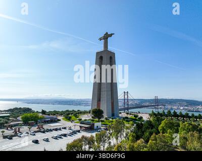 Almada, Portugal - 14 mai 2024 : vue du drone derrière le Christ Roi face au pont sur le Tage Banque D'Images