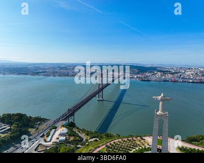 Almada, Portugal - 14 mai 2024 : vue du drone derrière le Christ Roi face au pont sur le Tage Banque D'Images