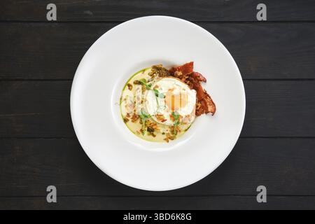 Vue de dessus de l'œuf frit avec tranches de bacon et frites servies avec une sauce crémeuse Banque D'Images