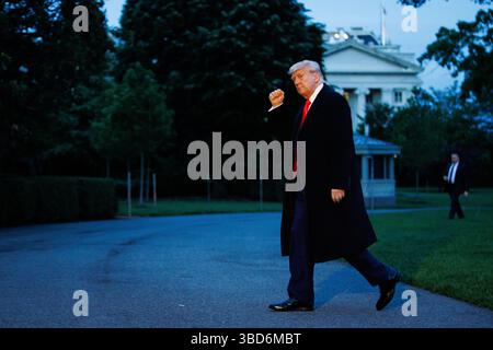 Le président des États-Unis Donald J Trump fait des gestes alors qu’il marche vers la Maison Blanche après avoir atterri sur la pelouse sud de la Maison Blanche à Washington, DC, États-Unis, à bord de Marine One le 22 mai 2025. Le président Trump revient du Trump National Golf Club en Virginie après un dîner privé. Crédit : Samuel Corum / piscine via CNP Banque D'Images