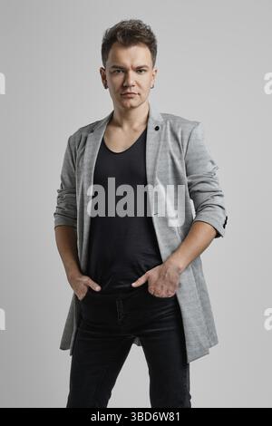 Portrait of a handsome man wearing wool veste, chemise noire et un jean Banque D'Images