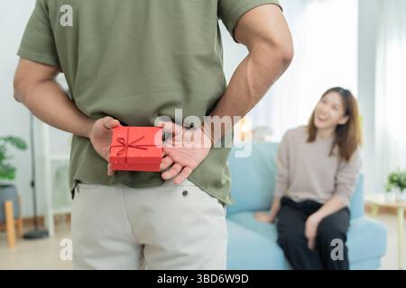 Heureux mari chercher et cacher la boîte cadeau pour femme surprise. boîte cadeau excitée fille mignonne. Anniversaire, célébration, Noël, Fête du nouvel an, merci, célébrer, Banque D'Images