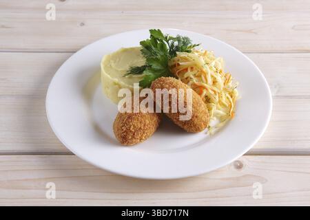 Côtelette de poulet Kiev avec chou mariné et purée de pommes de terre Banque D'Images
