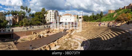 Teatro Romano ou Théâtre Romain Panorama à Malaga, Espagne vieille ville. Touristes marchant à la base des ruines antiques de la forteresse Alcazaba, lointaine ville Skyline Banque D'Images