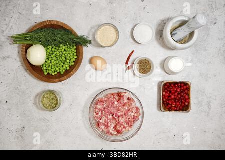 Vue de dessus des ingrédients pour boulettes de viande avec sauce aux canneberges et pois verts Banque D'Images