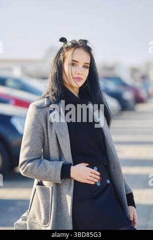 Jeune femme posant près du parking près du centre commercial Banque D'Images