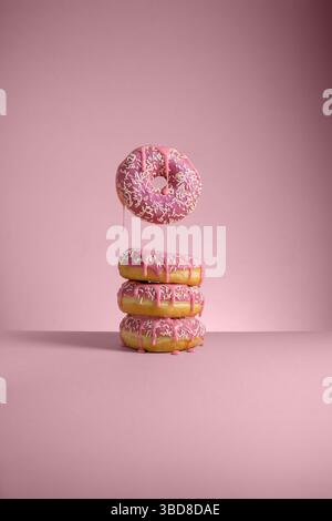 Beignets roses abstraits isolés sur fond rose lévitation Banque D'Images