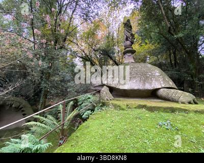 Grande tortue de pierre avec une statue sur le dos, entourée d'une végétation luxuriante dans le bois sacré, également connu sous le nom de Parc des monstres, à Bomarzo, Viterb Banque D'Images