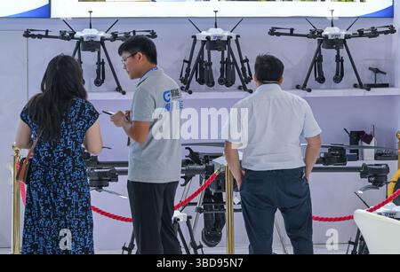 Chongqing. 23 mai 2025. Les gens regardent les drones à la 7ème Foire internationale de l'investissement et du commerce de Chine occidentale dans la municipalité de Chongqing, dans le sud-ouest de la Chine, le 23 mai 2025. La 7e Foire internationale de l'investissement et du commerce de Chine occidentale a débuté jeudi dans la municipalité de Chongqing, dans le sud-ouest de la Chine. Divers produits liés à l'économie de basse altitude ont attiré l'attention des visiteurs de la foire. Crédit : Chen Cheng/Xinhua/Alamy Live News Banque D'Images