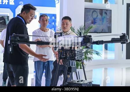 Chongqing. 23 mai 2025. Un exposant présente un drone de nettoyage de façade aux visiteurs de la 7e Foire internationale de l'investissement et du commerce de Chine occidentale dans la municipalité de Chongqing, dans le sud-ouest de la Chine, le 23 mai 2025. La 7e Foire internationale de l'investissement et du commerce de Chine occidentale a débuté jeudi dans la municipalité de Chongqing, dans le sud-ouest de la Chine. Divers produits liés à l'économie de basse altitude ont attiré l'attention des visiteurs de la foire. Crédit : Chen Cheng/Xinhua/Alamy Live News Banque D'Images