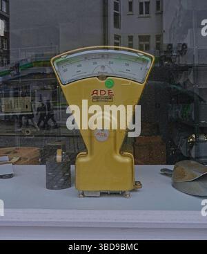 Echelle ADE jaune vintage dans une vitrine avec des reflets de la ville, capturée par un jour nuageux à Hambourg, en Allemagne Banque D'Images