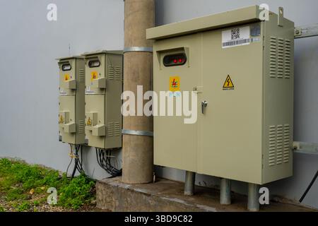 Bali, Indonésie - 22 décembre 2024 : trois boîtiers électriques sont fixés sur un mur. Les boîtes sont étiquetées PLN. Les boîtes sont reliées à un poteau Banque D'Images