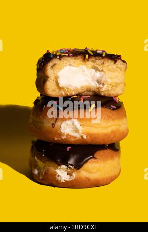 Trois Boston Cream Donuts sur fond jaune Banque D'Images