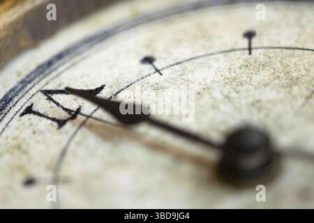 Une image détaillée en gros plan d'un cadran d'horloge vintage avec des aiguilles ornées, mettant en valeur le design complexe et la texture vieillie de la montre Banque D'Images