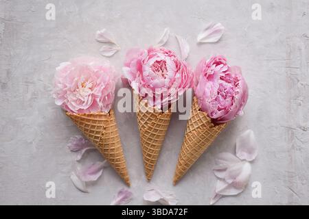Pivoines roses dans trois cônes de crème glacée gaufrés Banque D'Images