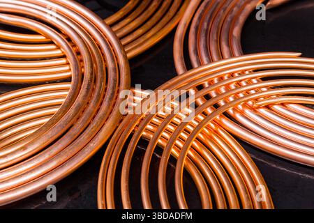 Nouveaux tubes en cuivre tordus sur un fond noir. Banque D'Images