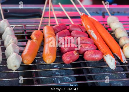La cuisine de rue thaïlandaise comprend des fruits de mer et des brochettes de poulet et de saucisses, y compris des pattes de crabe et des crevettes Banque D'Images