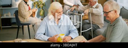 Les aînés socialisent et apprécient le café à la maison de soins infirmiers Banque D'Images